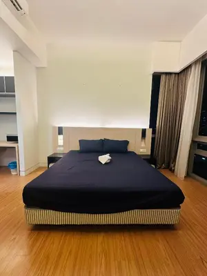 a bedroom with a large bed with a black blanket at Swiss Garden Resident By FA in Kuala Lumpur