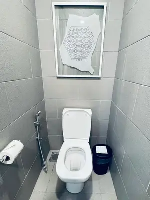 a bathroom with a toilet and a picture on the wall at 188 suites Apartment with KLCC View by Vho'Z in Kuala Lumpur