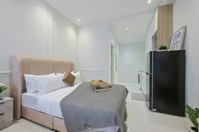 a bedroom with a large bed and a refrigerator at Majestic Residence near KLCC Quill City 1 in Kuala Lumpur