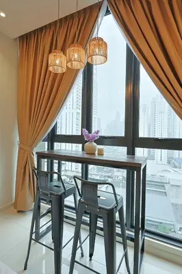 a dining room with a table and chairs in front of a window at Majestic Residence near KLCC Quill City 2 in Kuala Lumpur
