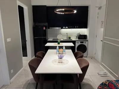 a kitchen with a white table with chairs and a counter at Akson Residensi Axon Bukit Bintang by TaheeenS in Kuala Lumpur