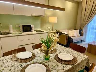 a kitchen with a table with plates and flowers on it at KL Sentral 16th Floor KL City View in Kuala Lumpur