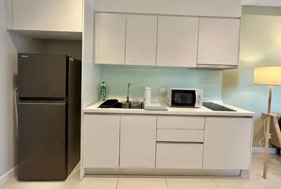 a kitchen with white cabinets and a black refrigerator at KL Sentral 16th Floor KL City View in Kuala Lumpur