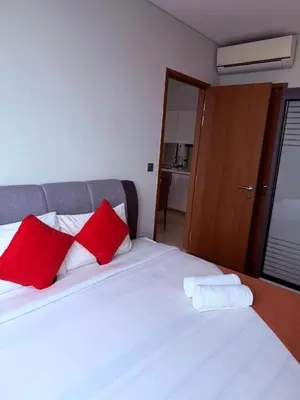 a bedroom with a bed with red and white pillows at Sky Suites KLCC by TD Luxury Homestay in Kuala Lumpur