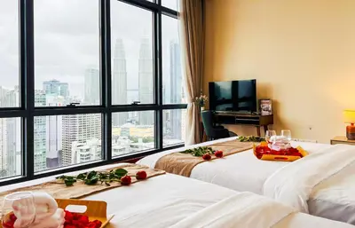 a hotel room with two beds and a large window at Manor Residences KLCC in Kuala Lumpur