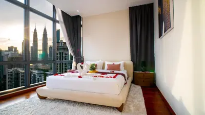 a bedroom with a white bed and a large window at KLCC View Suites with balcony at The Manor Residence in Kuala Lumpur