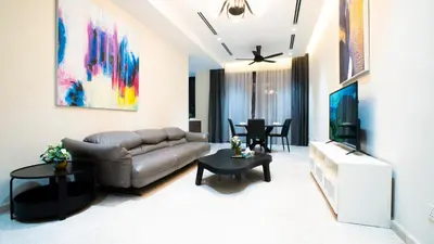 a living room with a couch and a television at KLCC View Suites with balcony at The Manor Residence in Kuala Lumpur