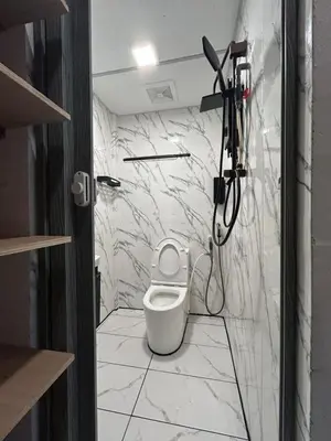 a bathroom with a white toilet and a shower at KING HOSTEL by Global Inn in Kuala Lumpur