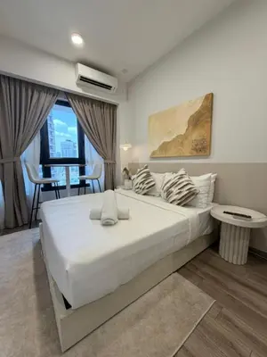a bedroom with a large white bed and a table at Residence Agile Apartment at kulalampur in Kuala Lumpur