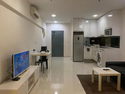 a living room with a tv and a kitchen at Summer Suites KLCC by Vho'Z in Kuala Lumpur