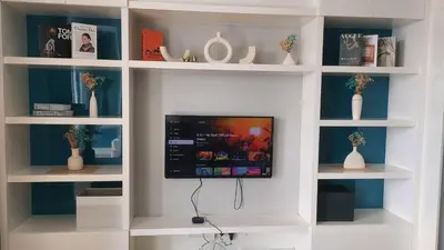 a room with a tv in a wall with shelves at Aura Suites at Platinum KLCC in Kuala Lumpur