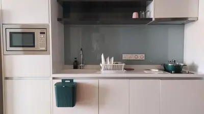 a kitchen with white cabinets and a microwave at Aura Suites at Platinum KLCC in Kuala Lumpur