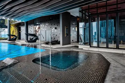 a large swimming pool in a building with a building at Scarletz Suites KLCC Rooftop Infinity Pool Near Twin Towers in Kuala Lumpur