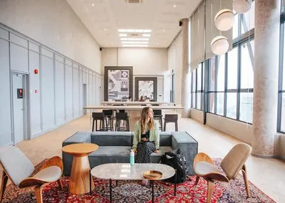 a woman sitting on a couch in an office lobby at Scarletz Suites KLCC Rooftop Infinity Pool Near Twin Towers in Kuala Lumpur