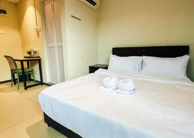 a bedroom with a large white bed with towels on it at Swing & Pillows - Sentul Jalan Ipoh Kuala Lumpur in Kuala Lumpur
