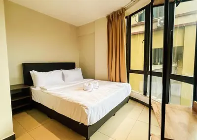 a bedroom with a bed with white sheets and a window at Swing & Pillows - Sentul Jalan Ipoh Kuala Lumpur in Kuala Lumpur