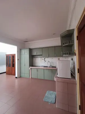 an empty kitchen with green cabinets and a tile floor at Sentul KL Private Cozy Bungalow Homestay - Free Parking & Wifi in Kuala Lumpur