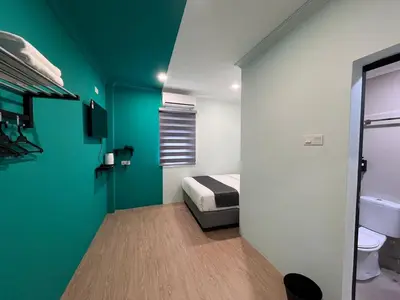 a room with a bed and a green wall at Alami Garden Hotel Kuala Lumpur in Kuala Lumpur
