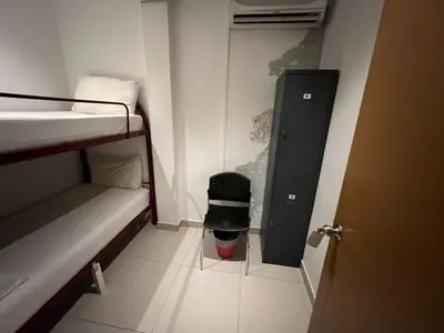 a small room with a bunk bed and a trash can at BG Travelers Home in Kuala Lumpur