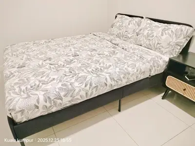 a bed with a white comforter on it in a room at Majestic Residence KLCC Royal Premium King Bed in Kuala Lumpur