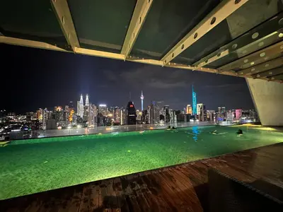 a rooftop pool with a view of a city at night at Regalia Apartments By FA 3 in Kuala Lumpur