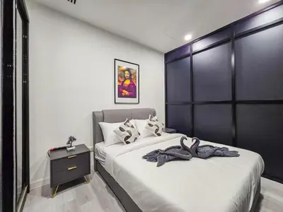 a bedroom with two beds and a black headboard at Binjai 8 Modern Suites by CityNest in Kuala Lumpur