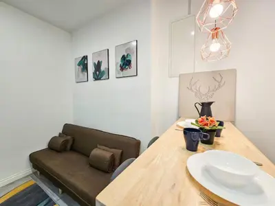 a dining room with a wooden table and a couch at Binjai 8 Modern Suites by CityNest in Kuala Lumpur