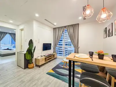 a living room with a table and a tv at Binjai 8 Modern Suites by CityNest in Kuala Lumpur