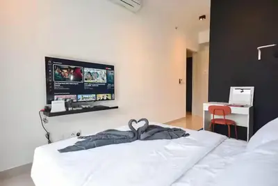 a bedroom with a bed with a tv on the wall at Trion 2 KL Cityview Suites by CityNest in Kuala Lumpur