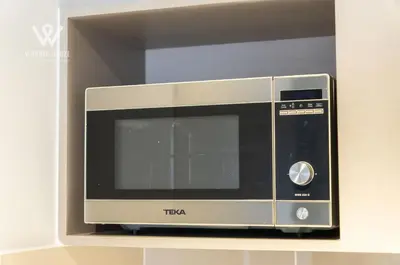 a microwave sitting on top of a shelf at 2BR Minimalist Urban Retreat at Trion KL in Kuala Lumpur