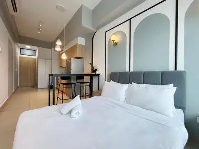 a bedroom with a white bed and a table at The Colony Infinitum By Paradgm Nest Stay in Kuala Lumpur