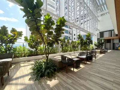 a cafeteria with tables and chairs in a building at The Colony Infinitum By Paradgm Nest Stay in Kuala Lumpur