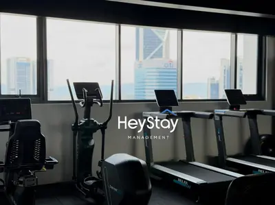 a gym with several tread machines in a room with windows at Isola KLCC by HeyStay Management in Kuala Lumpur