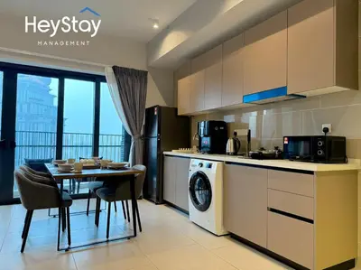 a kitchen and dining room with a table and a microwave at Isola KLCC by HeyStay Management in Kuala Lumpur
