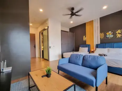a living room with a blue couch and a bed at KL City Designer Studio in Ceylonz with KL118 Tower View CityNest in Kuala Lumpur