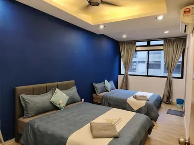 a bedroom with two beds and a blue wall at Fahrenheit 88 Suites, Bukit Bintang 4R in Kuala Lumpur
