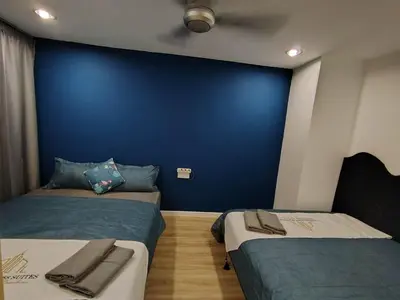 two beds in a room with a blue wall at Fahrenheit 88 Suites, Bukit Bintang 4R in Kuala Lumpur