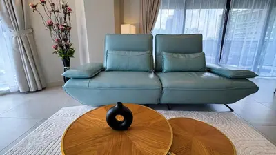 a living room with a blue couch and a table at The Atrium Jalan Ampang Elegant Fully Air-Con 3 BR Homestay in Kuala Lumpur