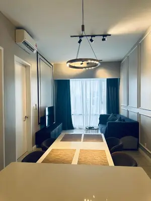 a living room with a table and a blue couch at Bukit Bintang Axon Residence By TRX in Kuala Lumpur