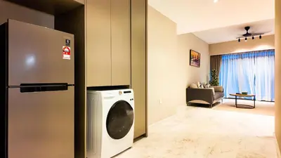 a kitchen with a refrigerator and a washing machine at Eaton Residence KLCC - Royal Home in Kuala Lumpur