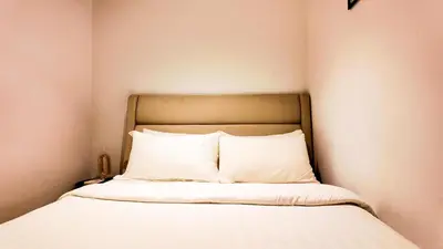 a bed with white sheets and pillows in a room at Eaton Residence KLCC - Royal Home in Kuala Lumpur