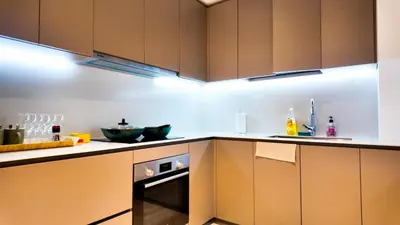 a kitchen with brown cabinets and an oven at Eaton Residence KLCC - Royal Home in Kuala Lumpur