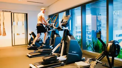 a man walking on a treadmill in a gym at Eaton Residence KLCC - Royal Home in Kuala Lumpur