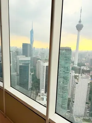 a view of a city skyline from a window at Sky Suites KLCC by Apartment TD Luxury in Kuala Lumpur