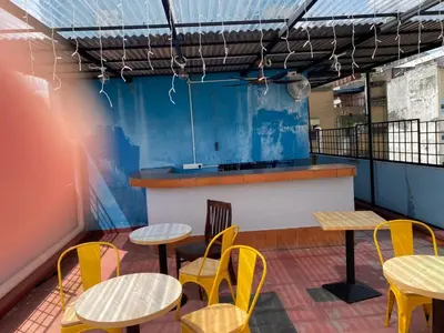 a patio with tables and chairs and a counter at China Town Dorm by ichiro in Kuala Lumpur