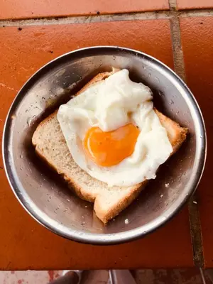 a fried egg on a piece of bread in a pan at China Town Dorm by ichiro in Kuala Lumpur