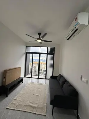 a living room with a black couch and a ceiling fan at star resdence in Kuala Lumpur