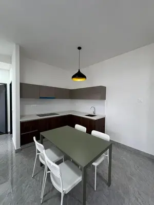 a kitchen with a table and white chairs in it at star resdence in Kuala Lumpur