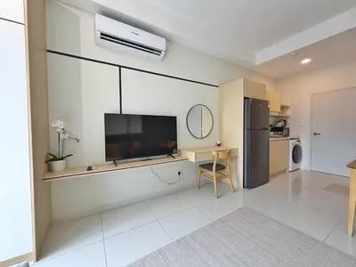 a living room with a flat screen tv on a wall at KLCC View Majestic Lovely Studio with Rooftop Pool in Kuala Lumpur