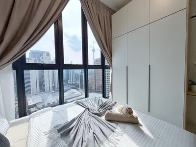 a bedroom with a bed with a large window at KLCC View Majestic Lovely Studio with Rooftop Pool in Kuala Lumpur